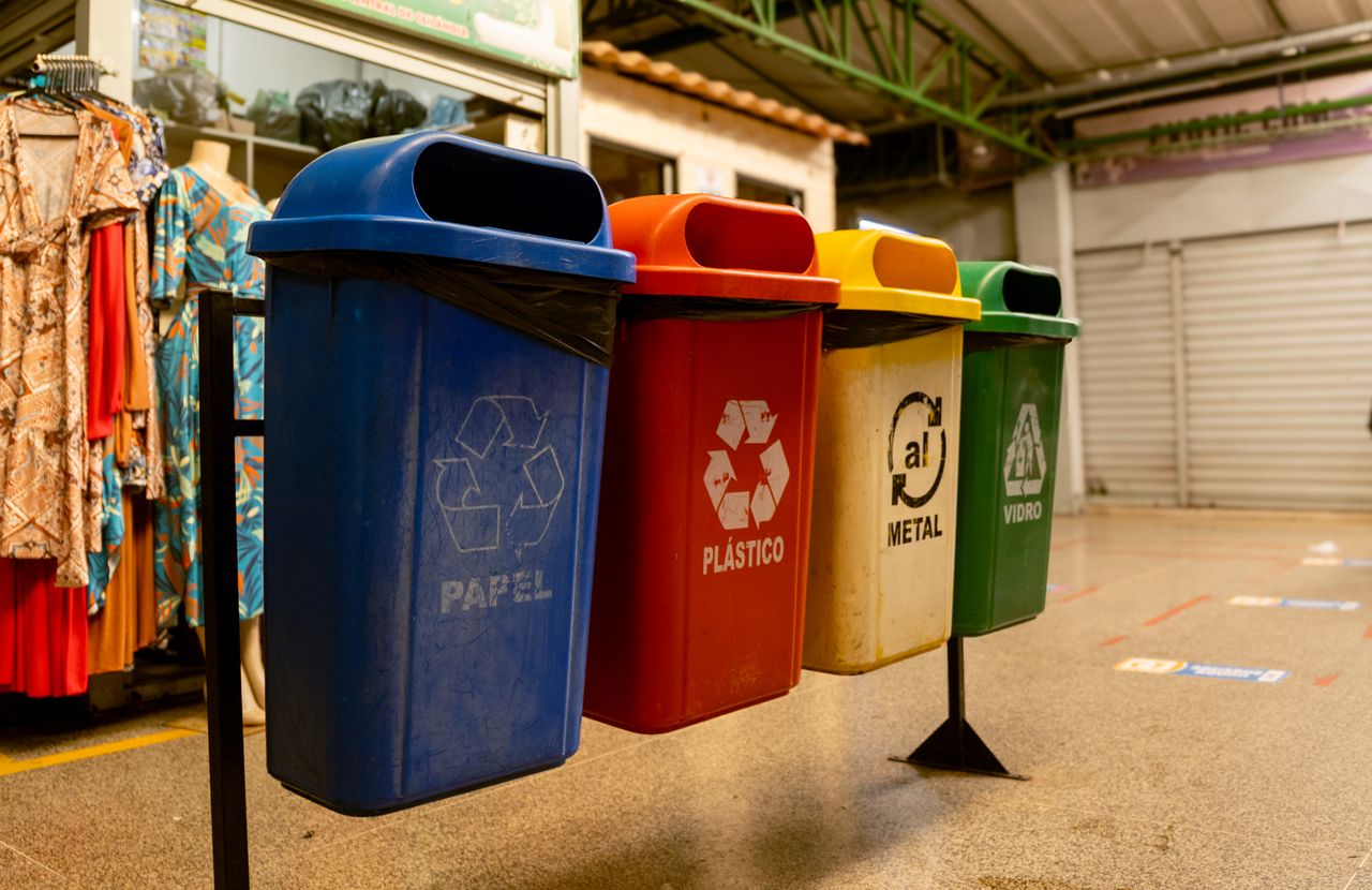 The Art of Drawing Readers In: Your attractive post title goes here Four recycling bins for paper, plastic, metal, and glass indoors.